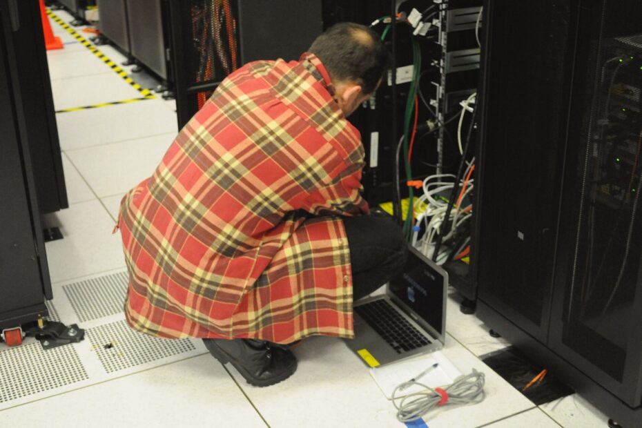 サーバーラックの前でノートPCを操作する技術者